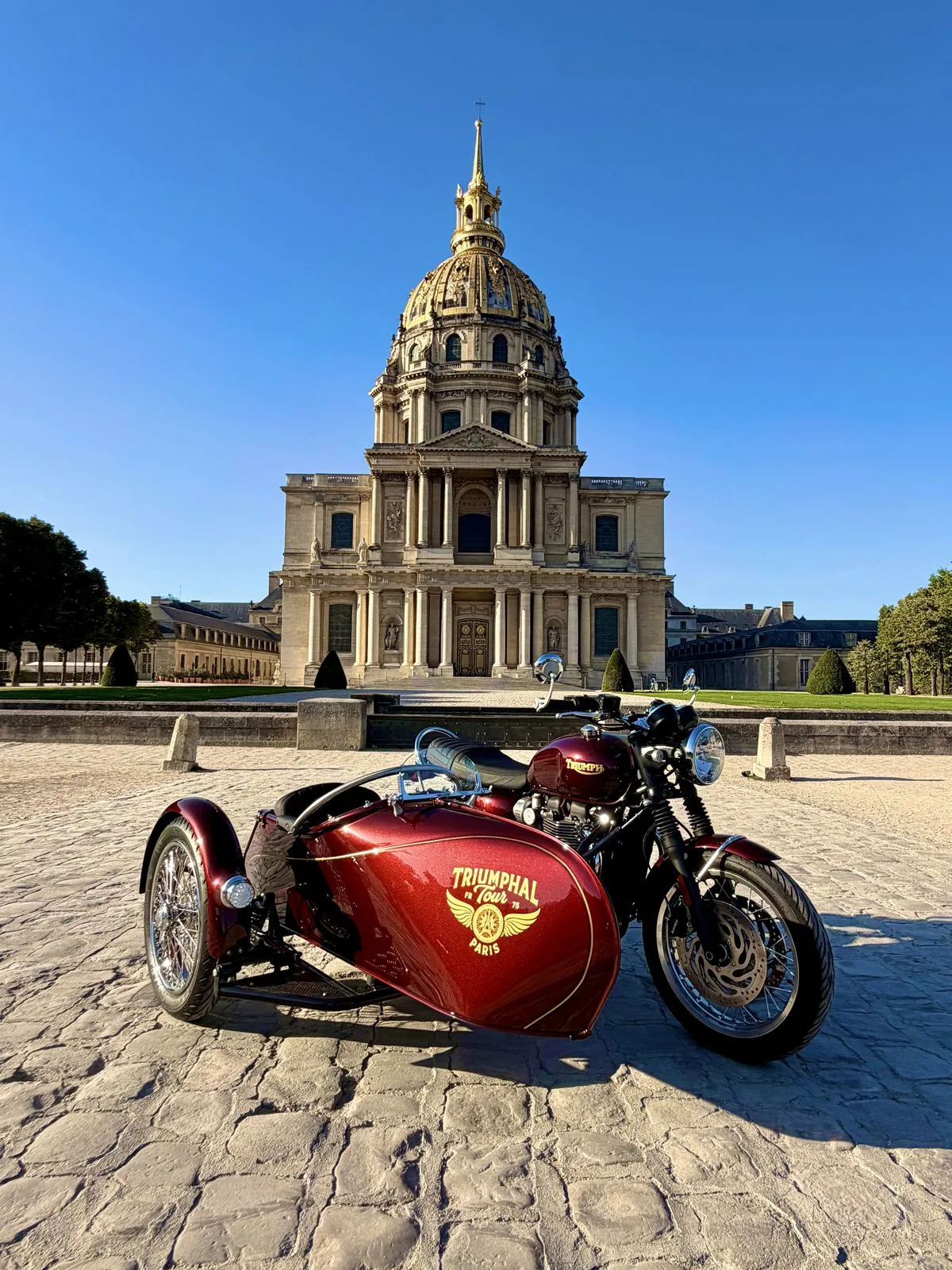 Side-car Triumph rouge de l'Iconic Tour devant les Invalides